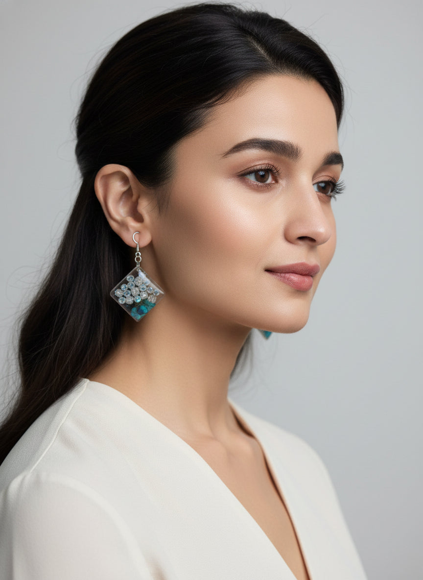 Square resin dangle earrings featuring crystal beads and preserved teal flowers